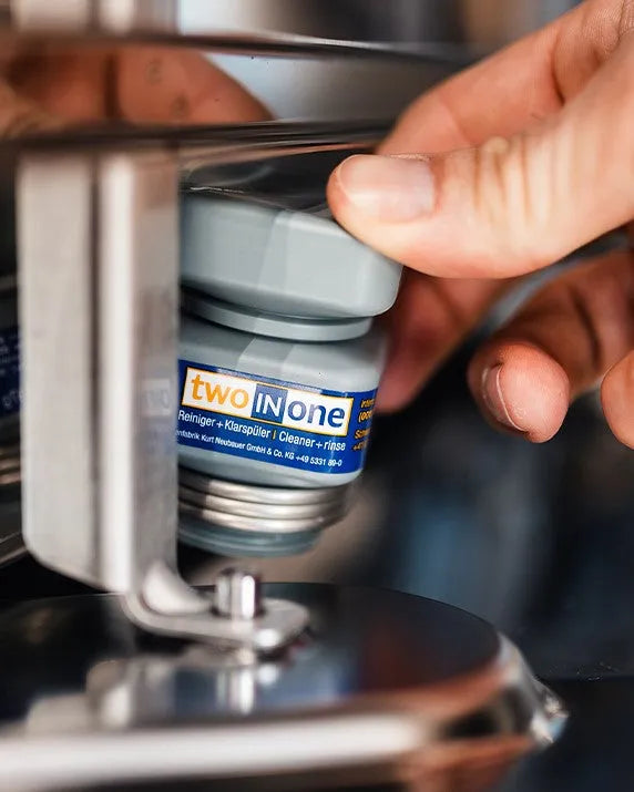 A hand fitting an MKN two-in-one cartridge into its port